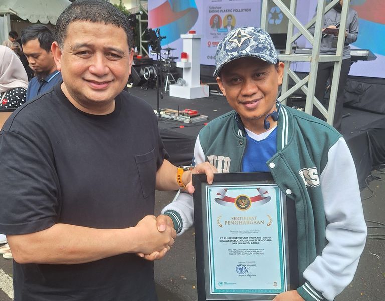 PENGHARGAAN -- Wali Kota Makassar, Munafri Arifuddin (kiri) memberikan penghargaan kepada PLN UID Sulselrabar yang diwakili Manager K3L dan Keamanan, Arman atas kontribusinya dalam Peringatan Hari Lingkungan Hidup Tingkat Kota Makassar pada Minggu (29/6).
