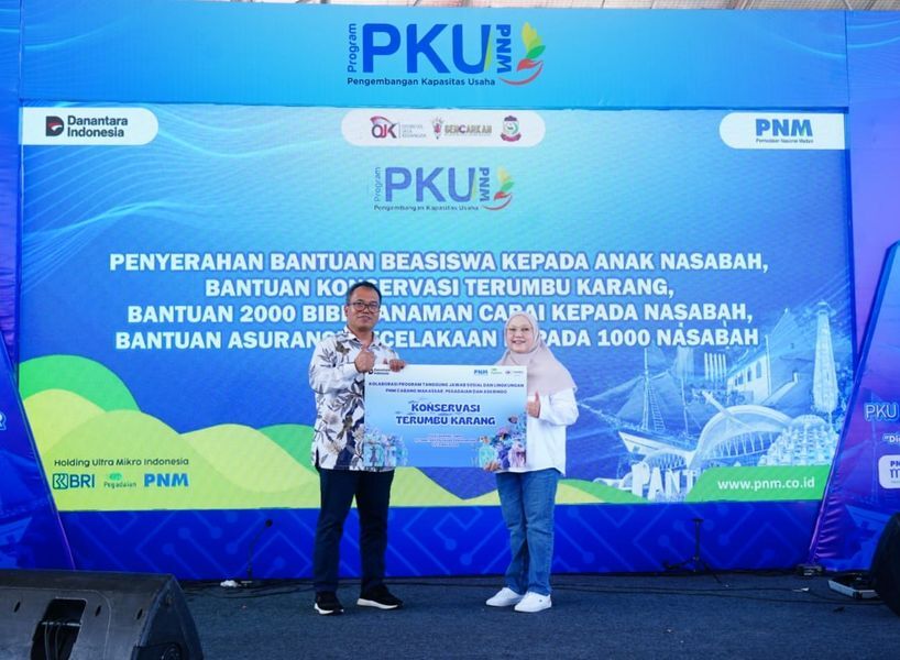 BANTUAN -- Pemimpin Wilayah PT Pegadaian Kanwil VI Makassar, Ngadenan kepada Pemimpin Cabang PNM Makassar, Maimun Bakri dalam kegiatan pelatihan nasabah Pengembangan Kapasitas Usaha (PKU) Akbar yang diselenggarakan PNM Makassar di Lapangan Karebosi, Kamis (19/6).