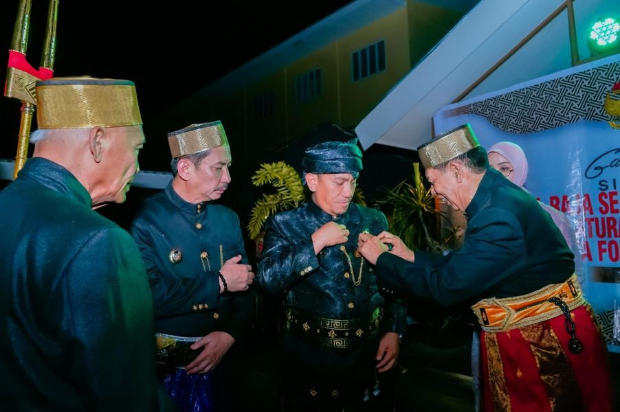 TUAN RUMAH -- Datu Luwu ke XL, YM Andi Maradang Mackulau Opu To Bau menyematkan pin kepada Bupati Luwu Timur Irwan Bachri Syam disela-sela kegiatan FSKN yang digelar, Sabtu (28/6).  Luwu bertindak sebagai tuan rumah.  