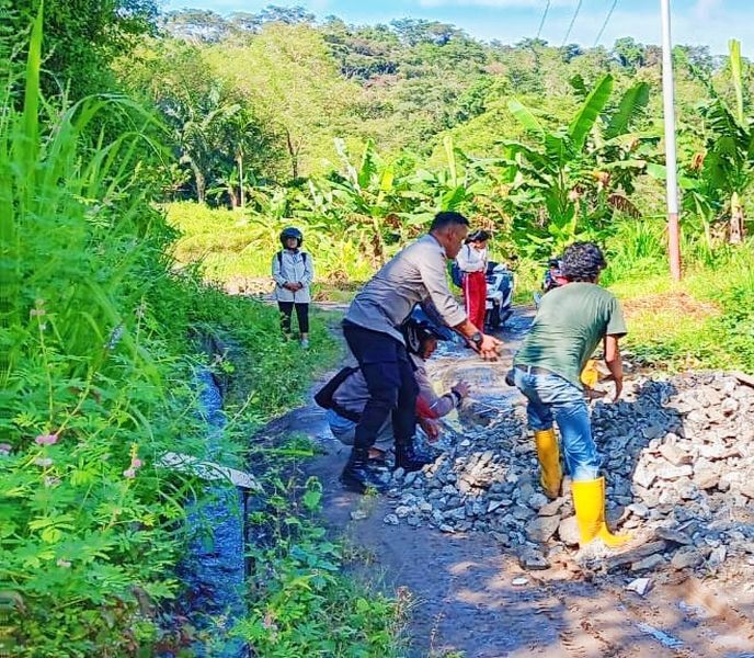 KERJA BAKTI -- Bhabinkamtibmas Polsek Bonggakaradeng bersama warga binaan kerja bakti membersihkan dan menimbun jalan berlumpur serta berlubang di Lingkungan Mariri, Lembang Mappa, Kecamatan Bonggakaradeng