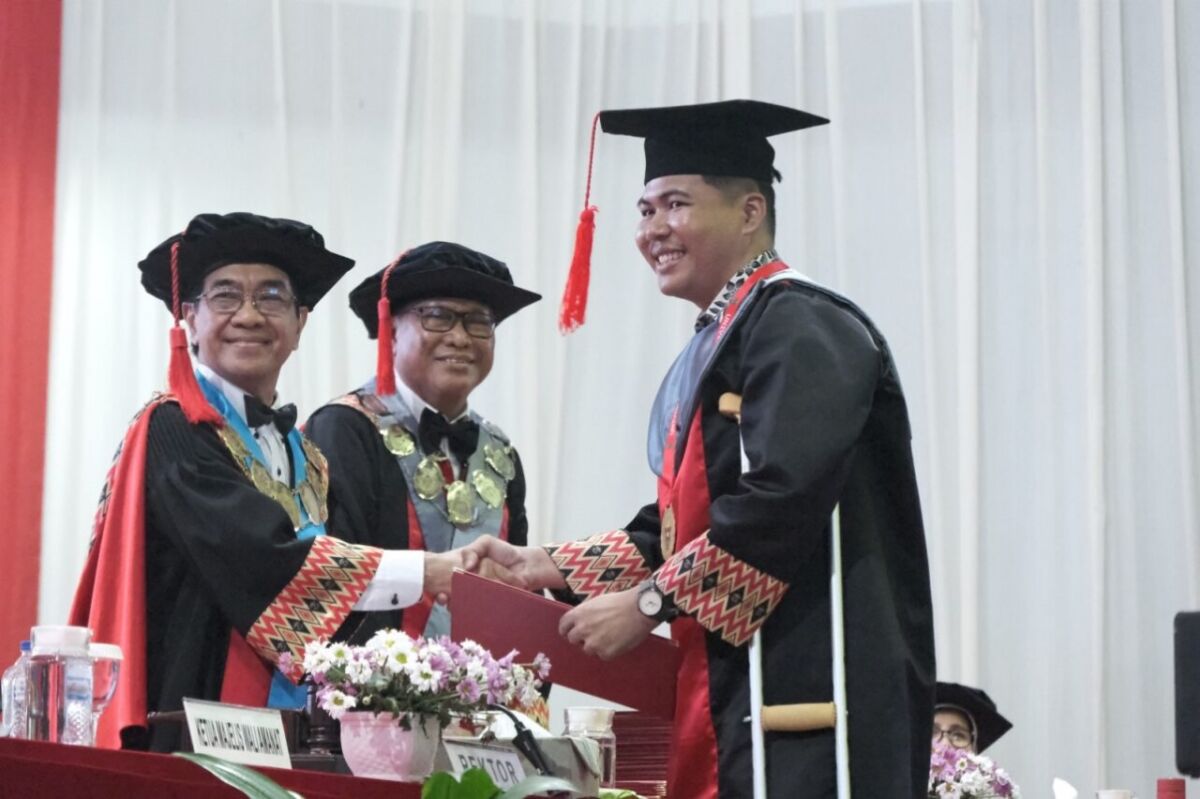 Rektor Unhas, Prof Jamaluddin Jompa menyampaikan selamat kepada Agum, penyandang disabilitas yang berhasil meraih gelar master saat wisuda, Selasa (15/7/2025).