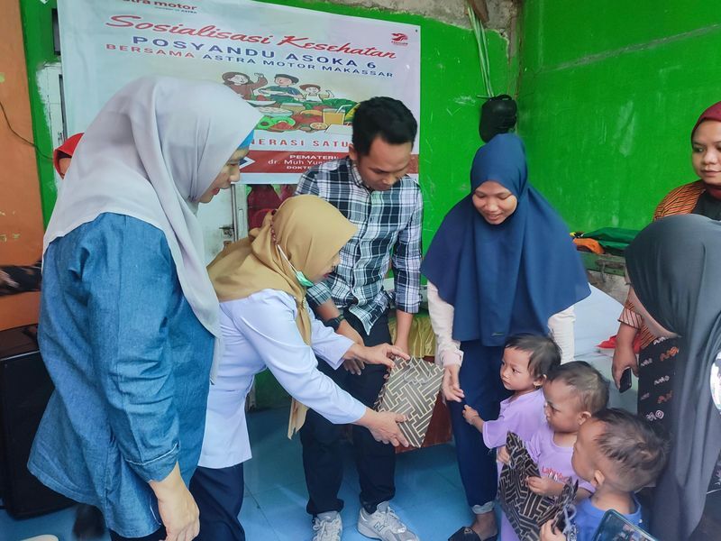 PAKET -- Ramlah Uslie dari Asmo Sulsel (kiri) menyaksikan pembagian paket kepada anak-anak Balita di Posyandu Asoka 6, Kota Makassar.
