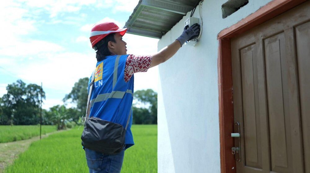 PEMASANGAN KWH -- Petugas PLN sedang melakukan pemasangan kWh meter di rumah pelanggan. 
