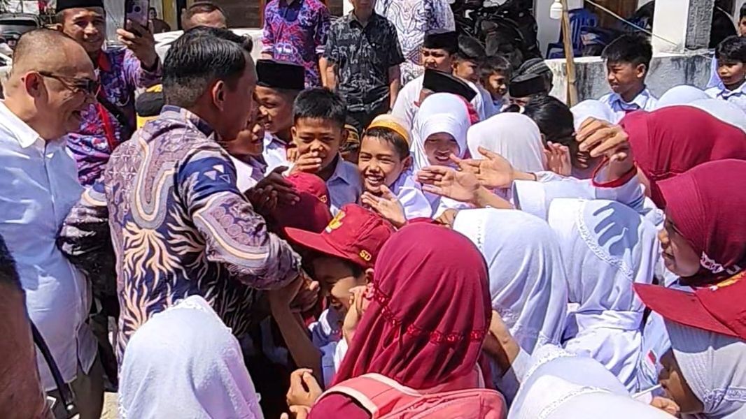 ANTAR ANAK -- Bupati Sidrap, H Syaharuddin Alrif ditengah-tengah murid SD salah satu sekolah di Kabupaten Sidrap, Senin (14/7). Dihari pertama masuk sekolah, Syahar mengimbau para ayah untuk mengantar anaknya melalui selembar  surat edaran. 
