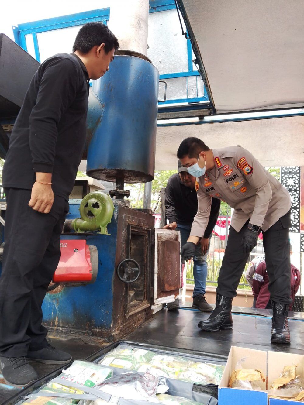 PEMUSNAHAN -- Kapolrestabes Makassar, Kombes Pol Arya Perdana sedang membakar narkotika di mesin penghancur barang bukti narkotika di depan halaman upacara Mapolrestabes Makassar. 
