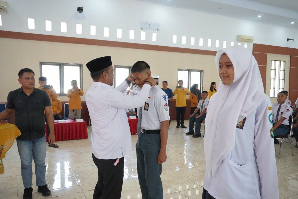 DIKLAT -- Bupati Luwu, H Patahudding menyematkan tanda peserta saat membuka secara resmi pemusatan Diklat Calon Paskibra Tahun 2025 di Aula Andi Kambo, Kompleks Perkantoran Bupati Luwu, Jumat (1/8).

