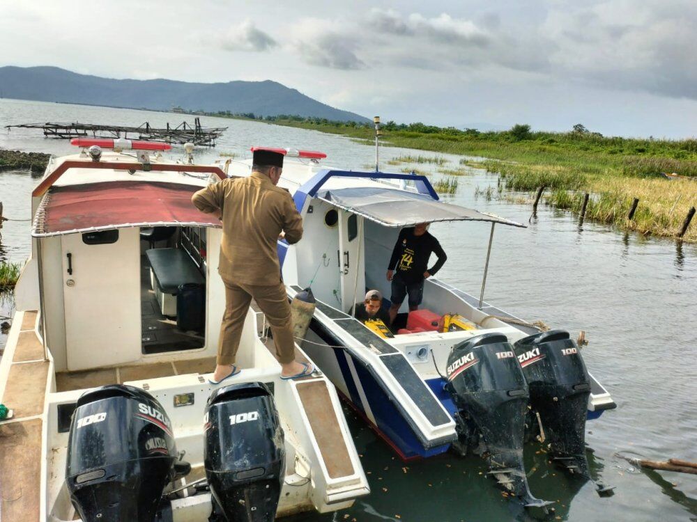 TINJAU -- Bupati Luwu Timur, H Irwan Bachri Syam meninjau dua unit ambulans danau yang bersandar di Pelabuhan Landak, Desa Bantilang, Kecamatan Towuti di sela suasana duka usai melepas jenazah almarhumah Aisyah Syam di Desa Rante Angin,  Senin (4/8). 
