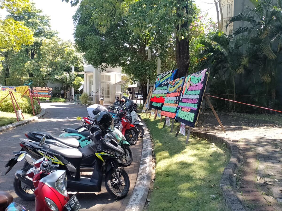 Karangan bunga terpasang di pinggir jalan pintu masuk rumah duka di Kompleks Perumahan Citraland Celebes.  