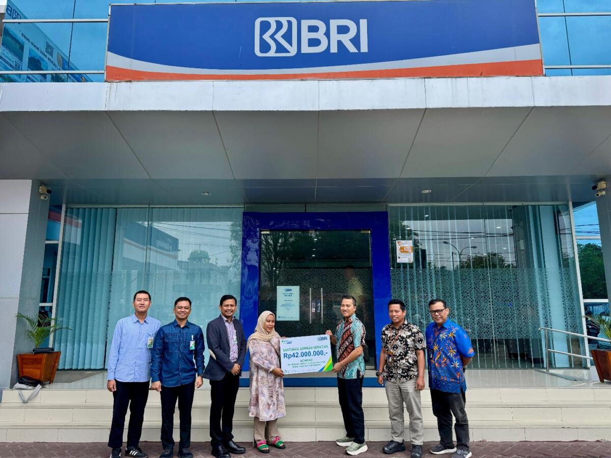SANTUNAN -- Pimpinan Cabang Bank Rakyat Indonesia Cabang Palopo, Atok Muhajir didampingi Kepala Cabang BPJS Ketenagakerjaan Palopo, Haryanjas Pasang Kamase, menyerahkan santunan JKM kepada ahli waris penerima Kredit Usaha Rakyat, Achmad.