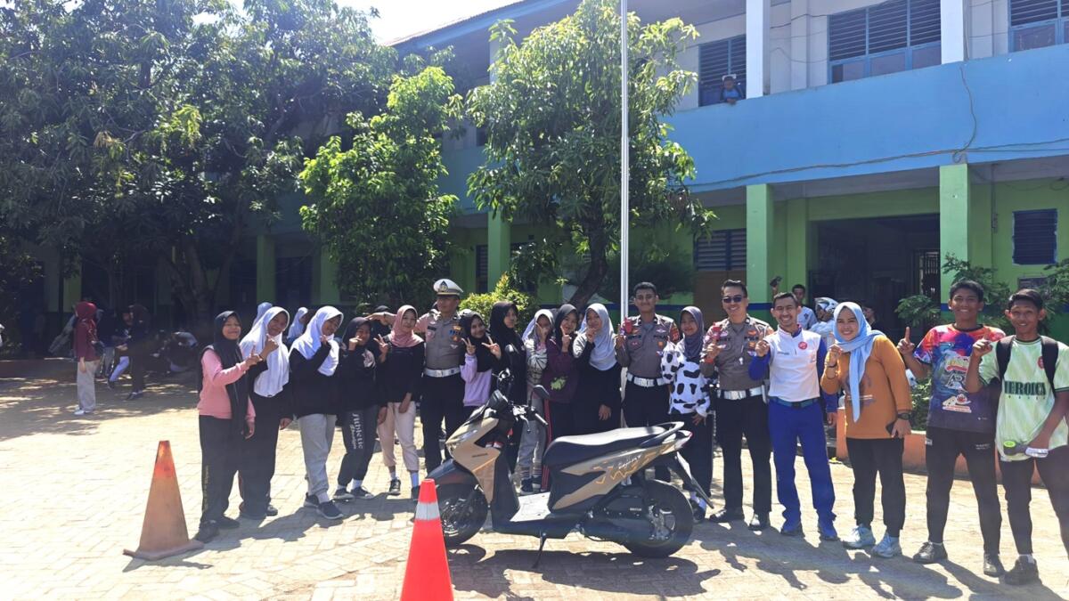 EDUKASI -- Instruktur Safety Riding Asmo Sulsel, Wanny bersama perwakilan dari Polres Gowa foto bersama dengan pelajar SMPN 4 Gowa saat melakukan safety riding di sekolah tersebut.

