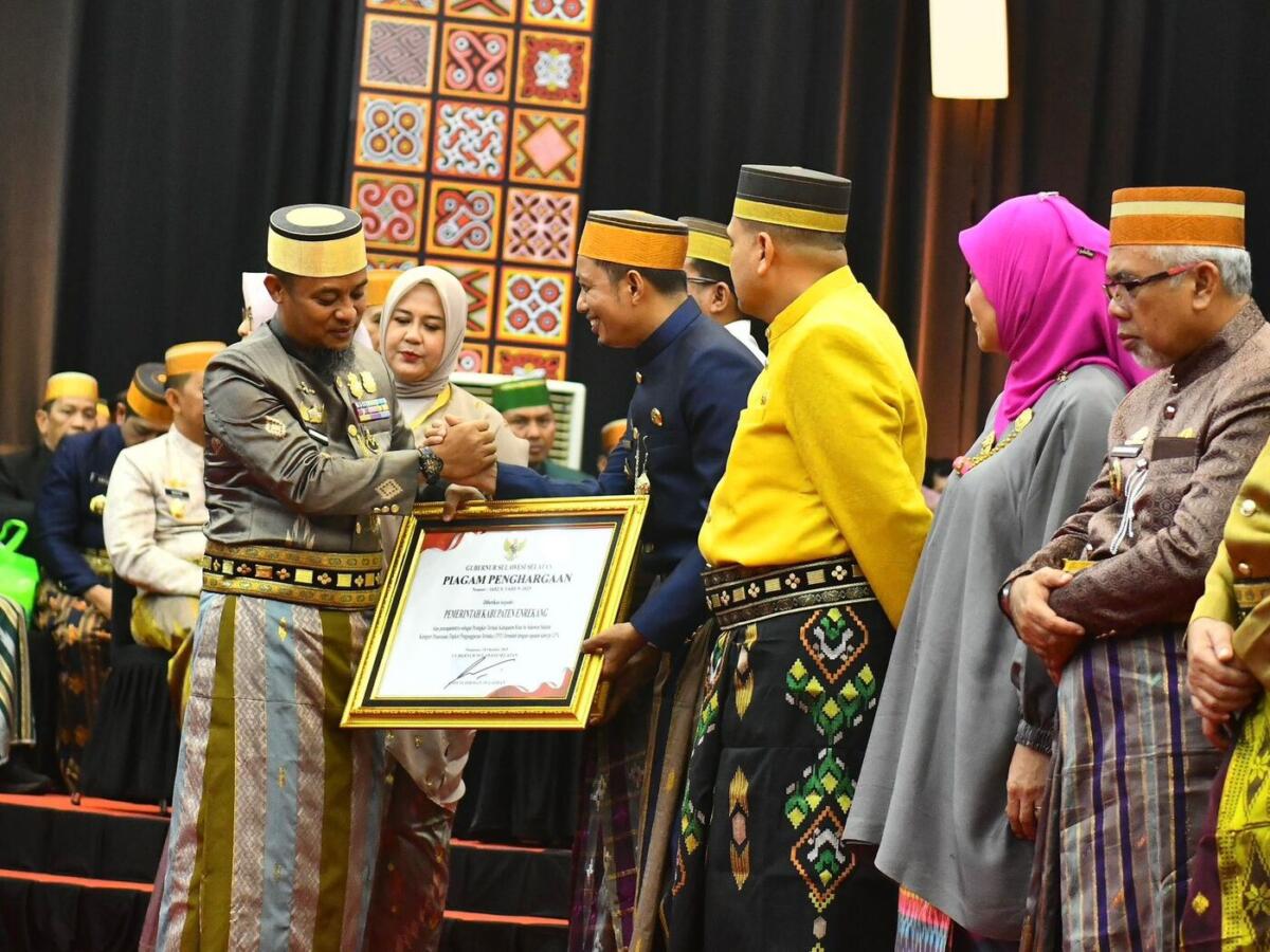 PENGHARGAAN -- Bupati Enrekang H. Muh. Yusuf Ritangnga menerima penghargaan dari Gubernur Sulsel Andi Sudirman Sulaiman pada puncak perayaan Peringatan Hari Jadi ke-356 Sulsel di Makassar, Minggu (19/10).