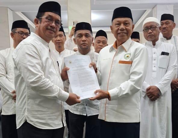Ketua DMI Kota Makassar H.M. Yunus HJ menyerahkan SK kepada Ketua Pengurus Masjid Darussalam Periode 2025-2028 H. Azis Bennu usai pelantikan dan pengukuhan.   