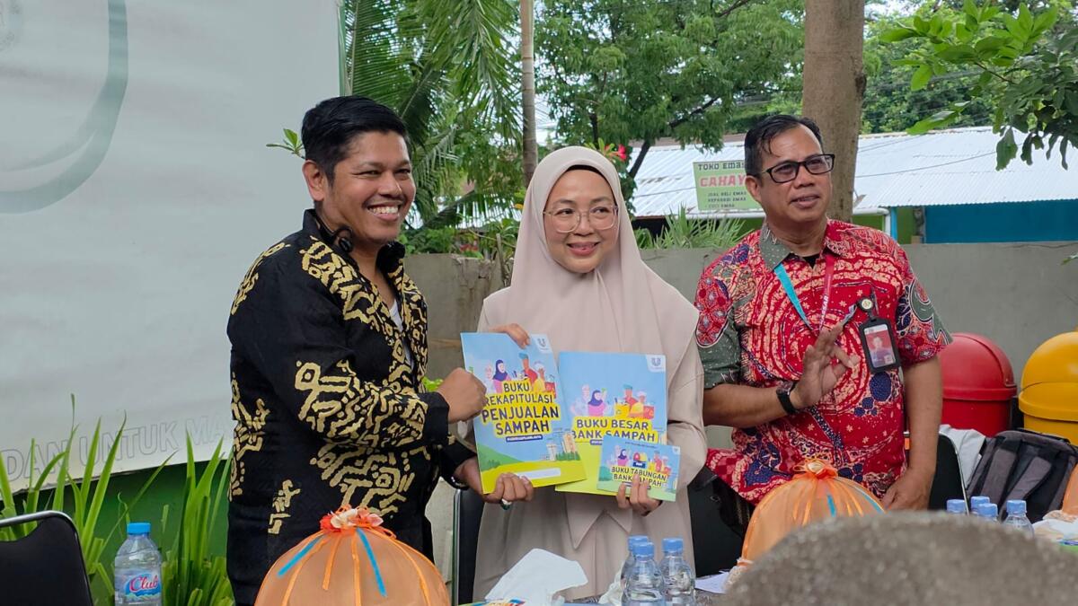 Ketua Yayasan Peduli Negeri, Saharuddin Ridwan menyerahkan buku tabungan bank sampah secara simbolis kepada Ketua Dewan Lingkungan Hidup Kota Makassar, Hj. Melinda Aksa, sebagai simbol dimulainya sistem administrasi dan akuntabilitas baru bagi Bank Sampah Unit.