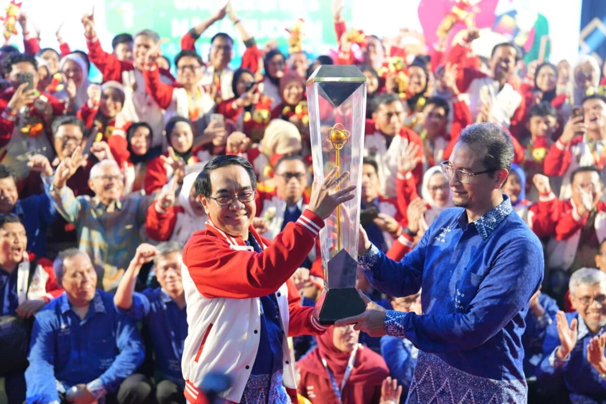 Rektor Unhas, Prof Jamaluddin Jompa menerima Piala Adikarta setelah Unhas juara umum Pimnas 2025 saat malam penutupan di JK Arenatorium Unhas, Jumat (28/11/2025) dini hari.