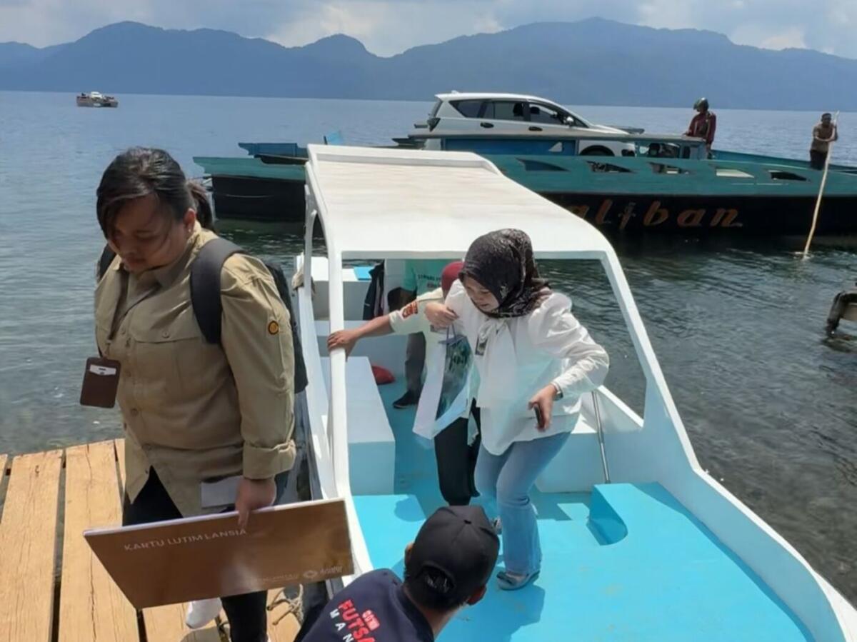 SEBRANGI DANAU -- Perhatian pemerintah terhadap warga lanjut usia di Luwu Timur benar-benar terwujud. Hal itu terlihat dari semangat petugas yang rela menyeberangi danau Matano di Desa Nuha, Kecamatan Nuha demi menyerahkan Kartu Lutim Lansia kepada seorang penerima 
