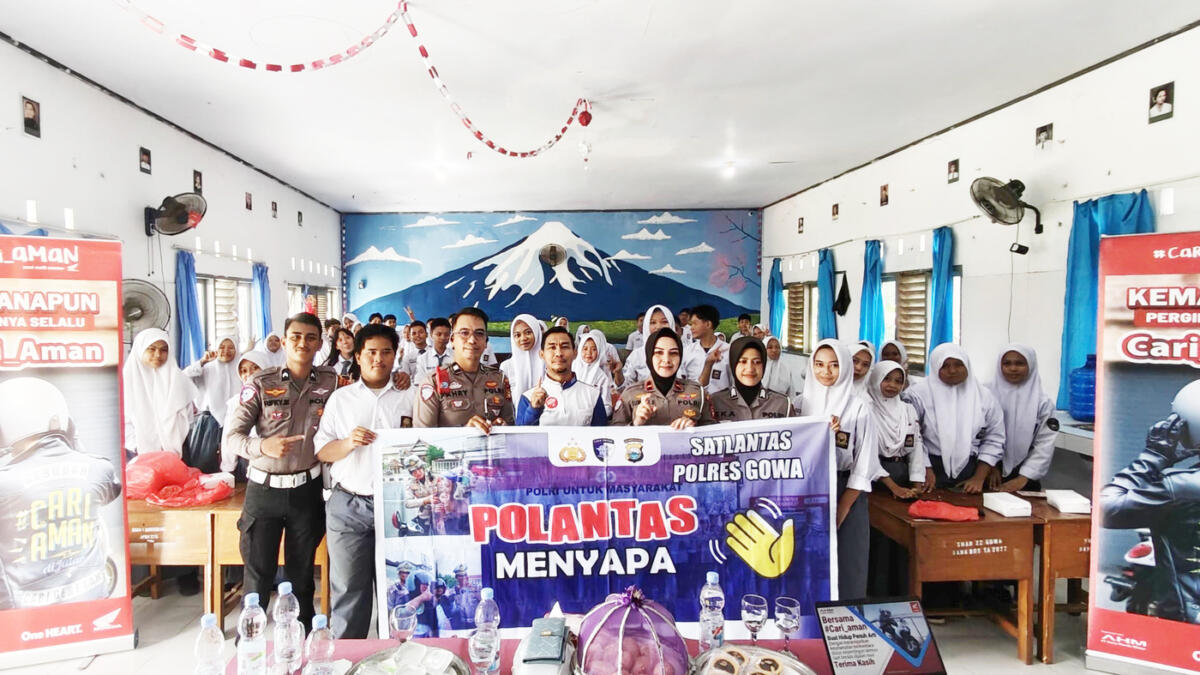 SAFETY RIDNG -- Instruktur  Safety Riding Asmo Sulsel, Wanny bersama jajaran kepolisian Satlantas Polres Gowa, kepala SMAN 22 Gowa bersama para siswanya foto bersama di sela mengikuti  gelaran safety riding