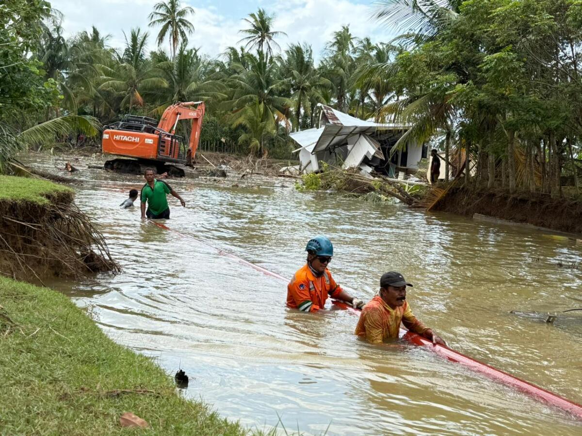 MOBILISASI -- Tim khusus PLN UID Sulselrabar dibantu masyarakat tengah memobilisasi tiang melewati akses yang masih terendam banjir di Desa Kuala Kereutou, Kecamatan Lapang, Kabupaten Aceh Utara pada Selasa (9/12).