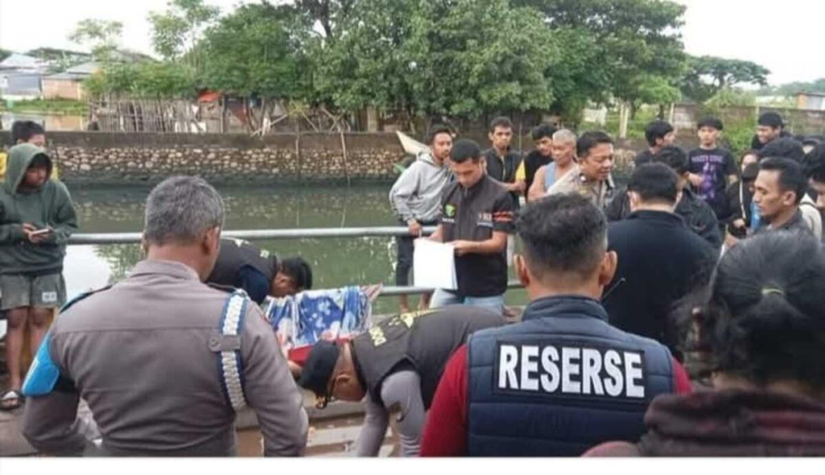 PENEMUAN MAYAT -- Warga bersama personel kepolisian menyaksikan mayat perempuan yang terampung di aliran Kanal Jalan Nuri Baru. 
