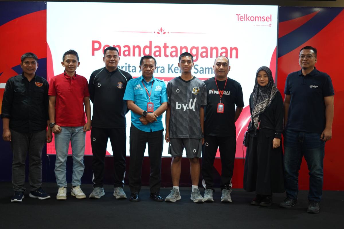 KEMITRAAN -- GM Consumer Business Growth and Channel Partnership Telkomsel Area Pamasuka, Muhammad Asrullah (kiri) dan 
Kepala SMA Negeri 8 Makassar, Iwanuddin (empat dari kiri) melakukan foto bersama usai menandatangani perjanjian kemitraan di antara kedua belah pihak.