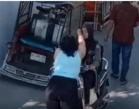 ANIAYA -- Seorang wanita yang mengalami gangguan jiwa mengadang seorang perempuan yang mengendarai sepeda motor lalu menganiayanya. 